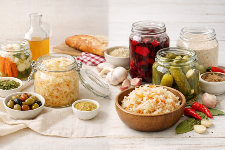 Chou fermenté, cornichons et zakwas présentés sur une table lumineuse, entre traditions culinaires française et polonaise